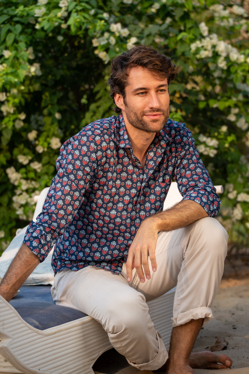 Man sitting outdoors wearing a patterned shirt