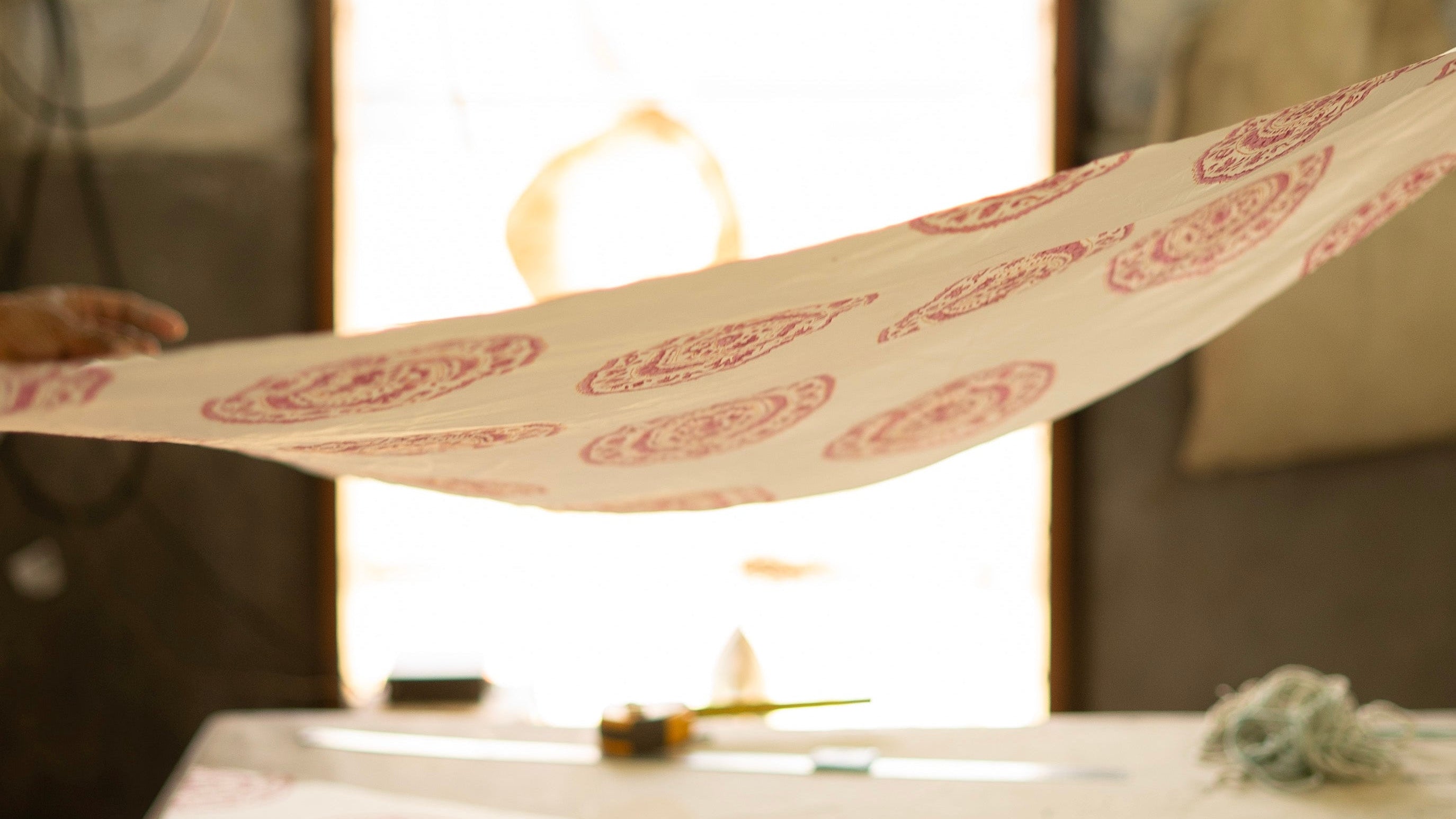 Person holding a long strip of paper with red patterns