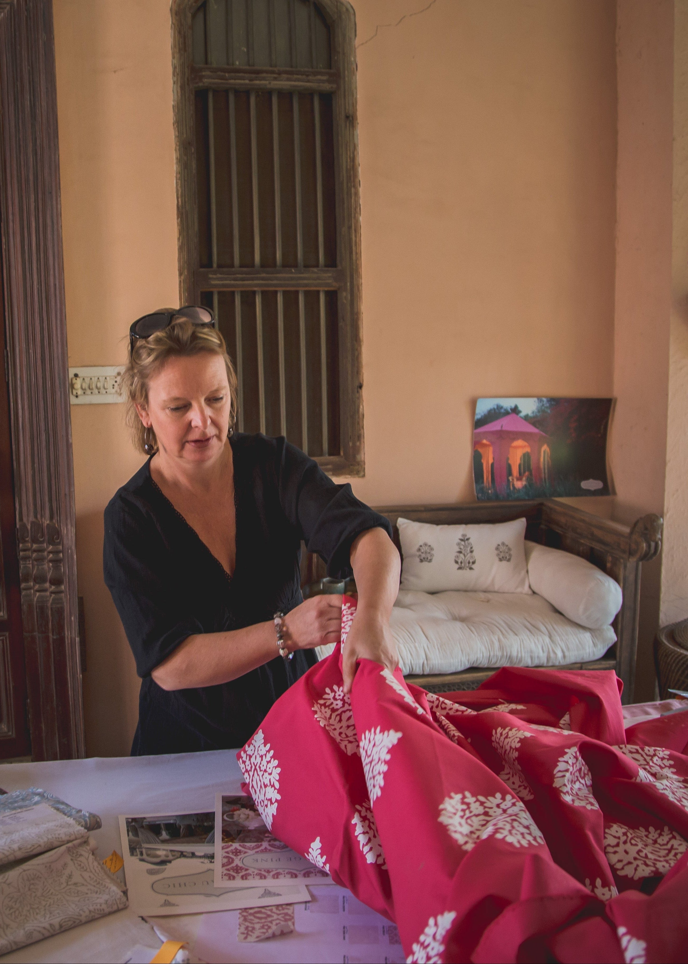 Woman arranging fabric in a room with decorative elements